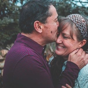 man-in-maroon-shirt-kissing-woman-on-forehead-1835909