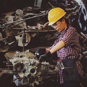 woman-wears-yellow-hard-hat-holding-vehicle-part-1108101 (1)